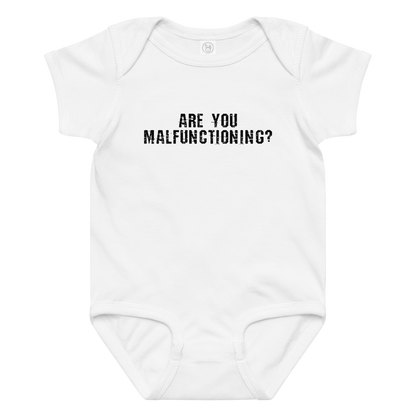 "Are you malfunctioning?" printed on a white baby jersey bodysuit laying on a flat surface amongst other clothes