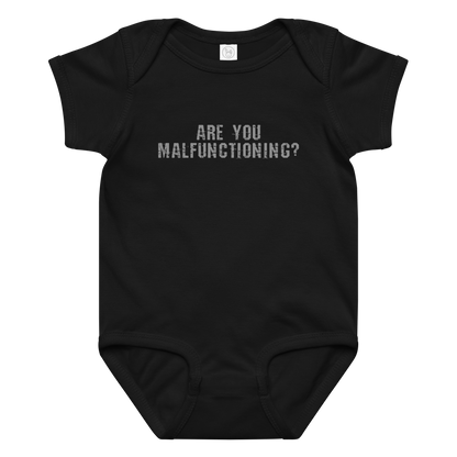 "Are you malfunctioning?" printed on a black baby jersey bodysuit laying on a flat surface amongst other clothes