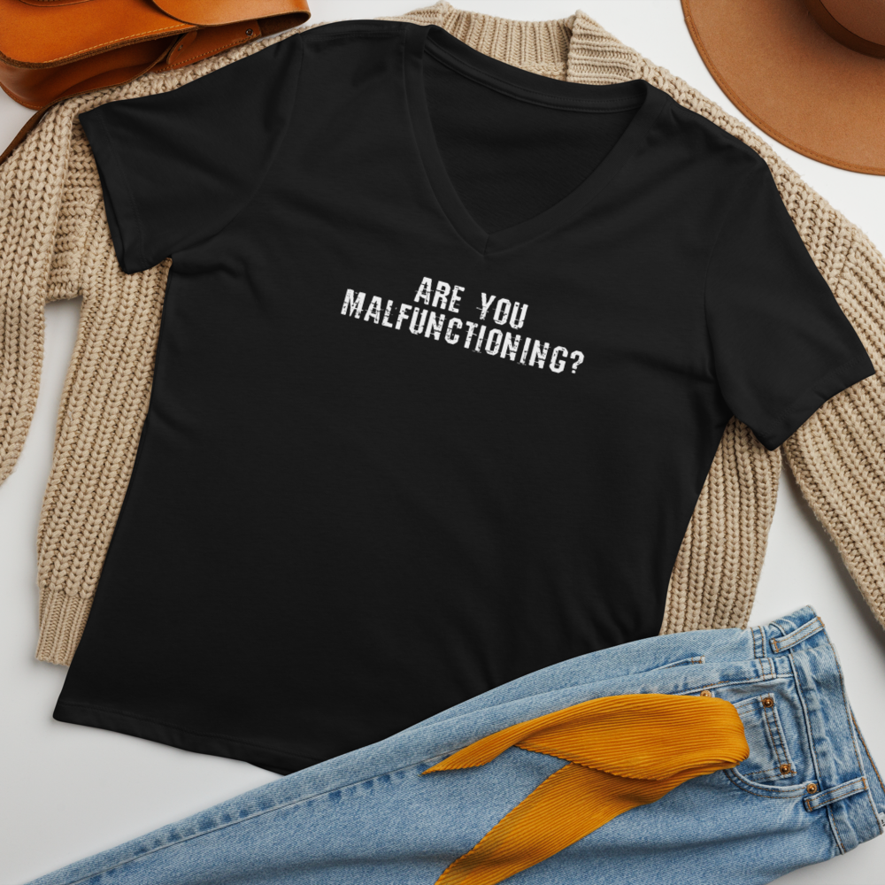 "Are you malfunctioning?" printed on a solid black blend women's relaxed v-neck t-shirt laying on a flat surface amongst other clothes