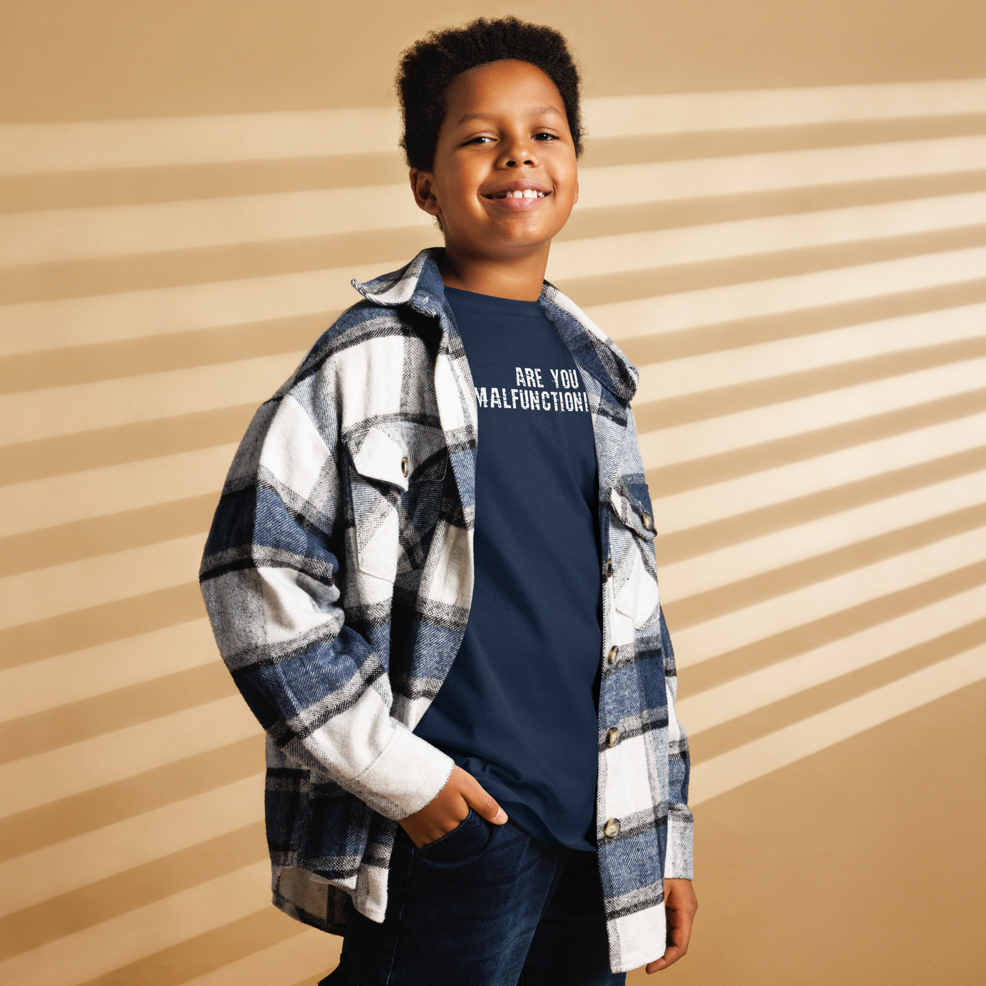 "Are you malfunctioning?" printed on a navy youth classic tee worn by a male also wearing a jacket