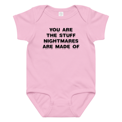 "You are the stuff nightmares are made of" printed on a pink baby jersey bodysuit laying on a flat surface amongst other clothes