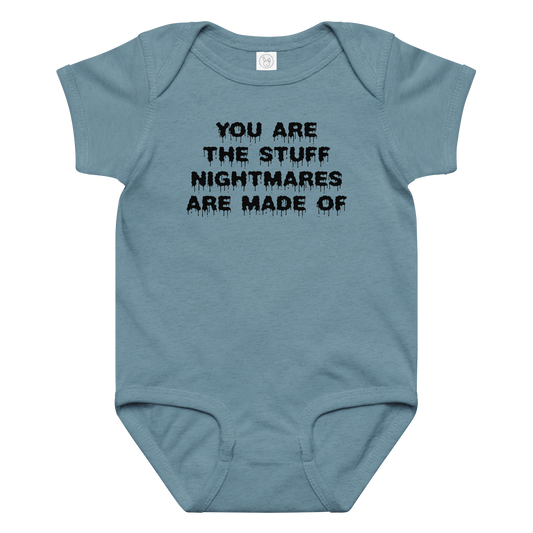 "You are the stuff nightmares are made of" printed on a vintage indigo baby jersey bodysuit laying on a flat surface amongst other clothes