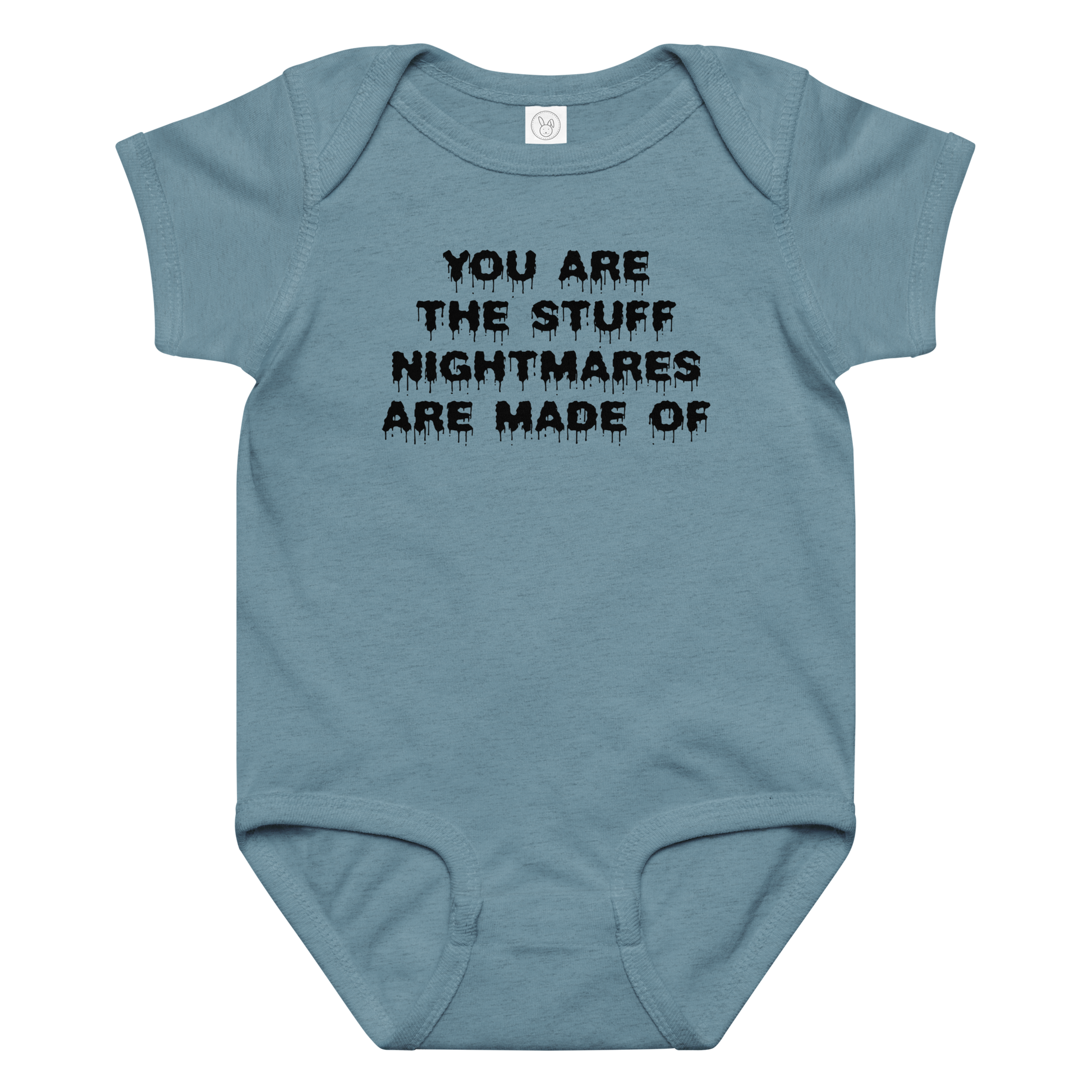 "You are the stuff nightmares are made of" printed on a vintage indigo baby jersey bodysuit laying on a flat surface amongst other clothes