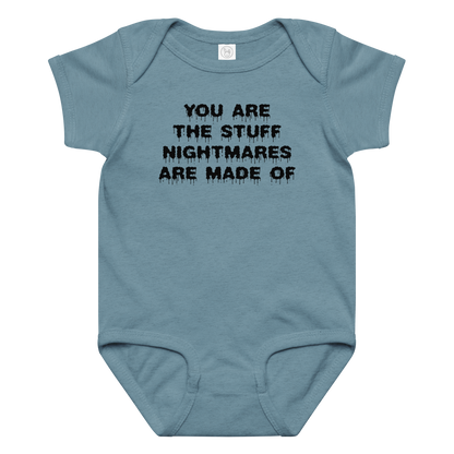 "You are the stuff nightmares are made of" printed on a vintage indigo baby jersey bodysuit laying on a flat surface amongst other clothes