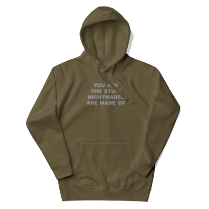 "You are the stuff nightmares are made of" printed on a military green unisex hoodie laying on a flat surface with the hood up