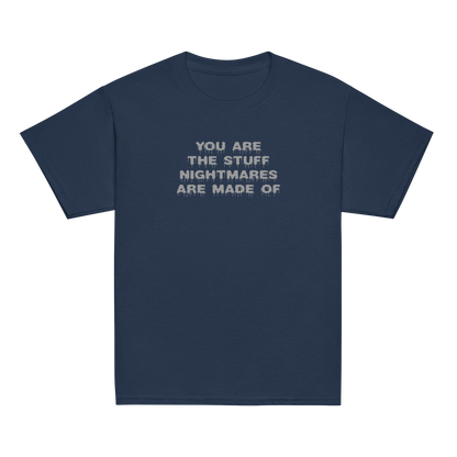 "You are the stuff nightmares are made of" printed on a navy youth classic tee laying on a flat surface