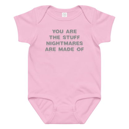 "You are the stuff nightmares are made of" printed on a pink baby jersey bodysuit laying on a flat surface amongst other clothes