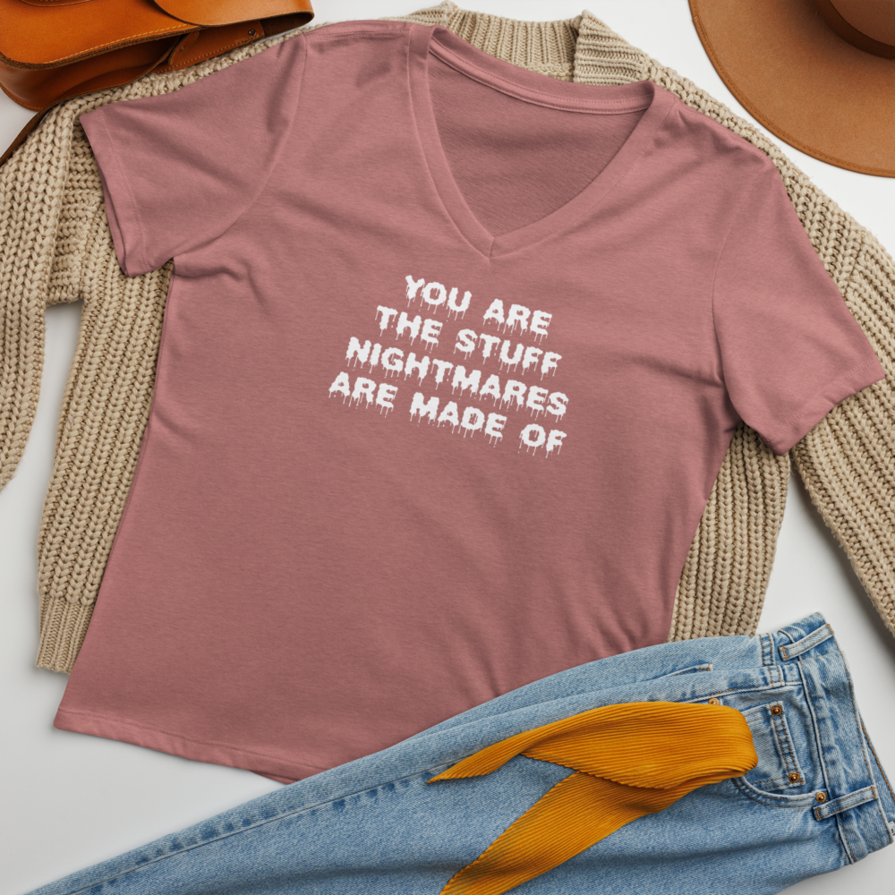 "You are the stuff nightmares are made of" printed on a heather mauve women's relaxed v-neck t-shirt laying on a flat surface amongst other clothes