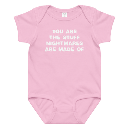 "You are the stuff nightmares are made of" printed on a pink baby jersey bodysuit laying on a flat surface amongst other clothes