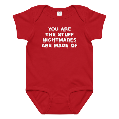 "You are the stuff nightmares are made of" printed on a red baby jersey bodysuit laying on a flat surface amongst other clothes