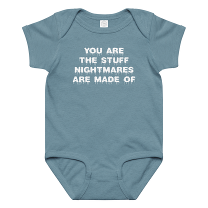 "You are the stuff nightmares are made of" printed on a vintage indigo baby jersey bodysuit laying on a flat surface amongst other clothes