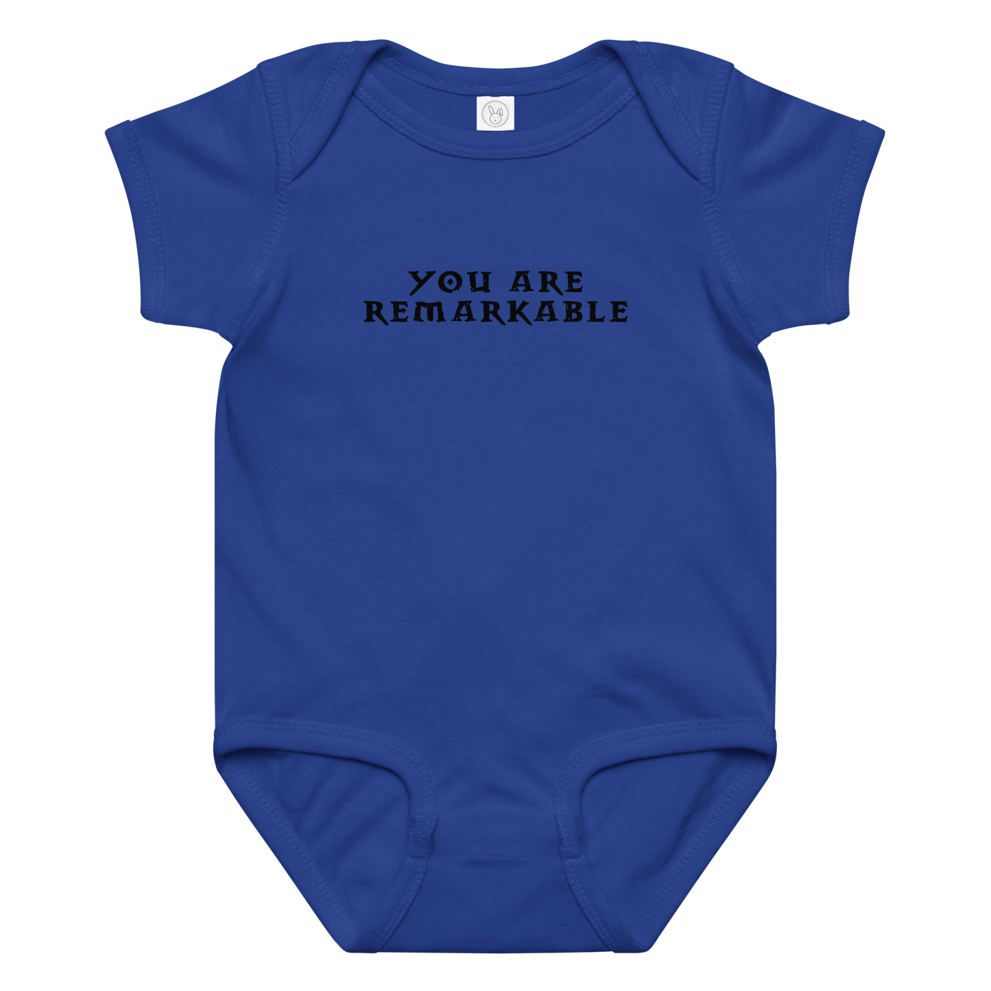 "You are remarkable" printed on a royal baby jersey bodysuit laying on a flat surface amongst other clothes