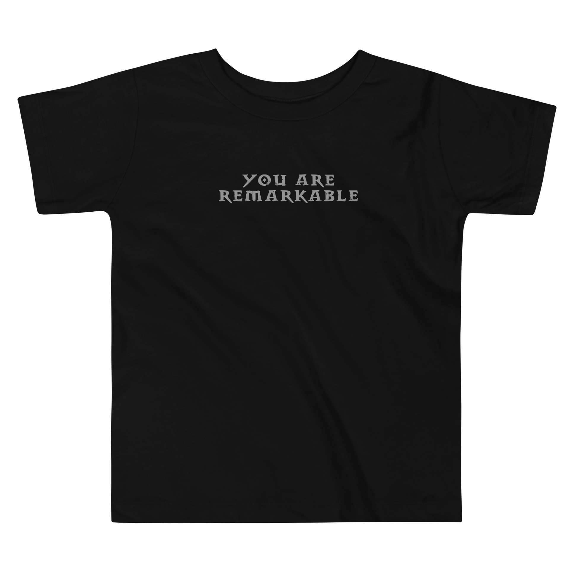 "You are remarkable" printed on a black toddler short sleeve tee laying on a flat surface
