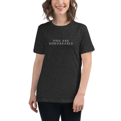 "You are remarkable" printed on a dark grey heather women's relaxed t-shirt worn by a female