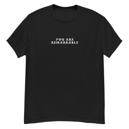 "You are remarkable" printed on a black unisex classic tee laying on a flat surface