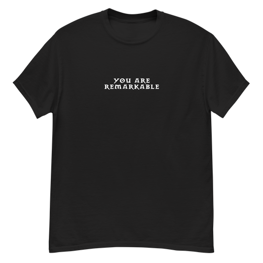 "You are remarkable" printed on a black unisex classic tee laying on a flat surface