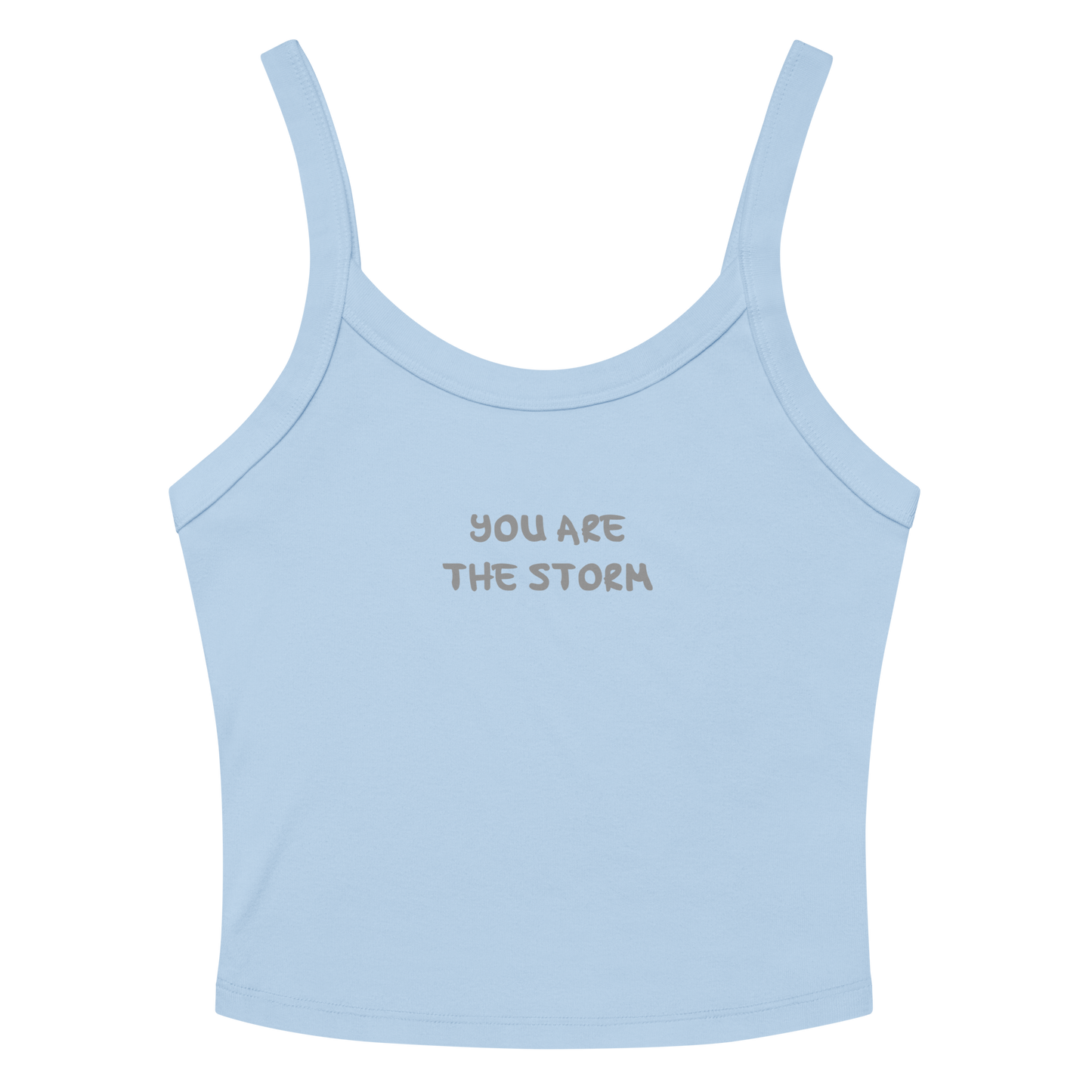 "You are the storm" printed on a solid baby blue blend women's micro-rib tanktop laying on a flat surface amongst sunglasses and shorts