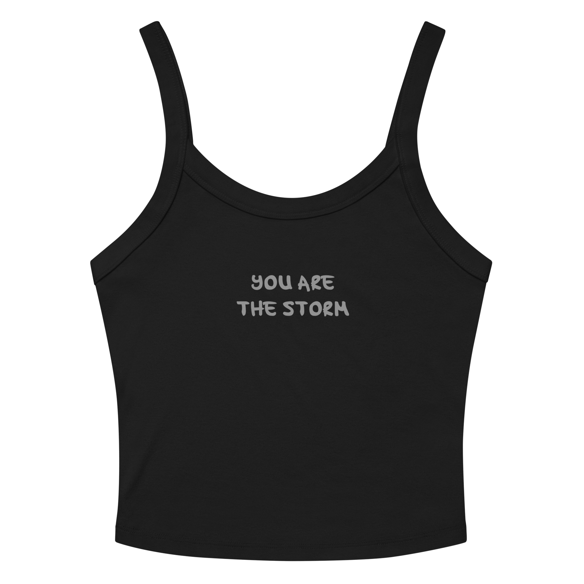 "You are the storm" printed on a solid black blend women's micro-rib tanktop laying on a flat surface amongst sunglasses and shorts
