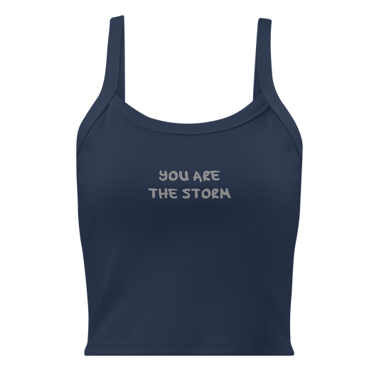 "You are the storm" printed on a solid navy blend women's micro-rib tanktop laying on a flat surface