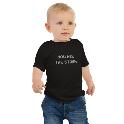 "You are the storm" printed on a black baby jersey short sleeve tee worn by a male