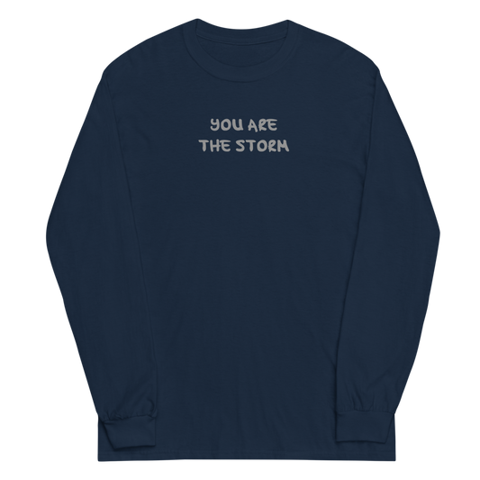 "You are the storm" printed on a navy men's long sleeve shirt laying on a flat surface