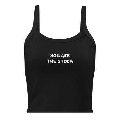 "You are the storm" printed on a solid black blend women's micro-rib tanktop laying on a flat surface