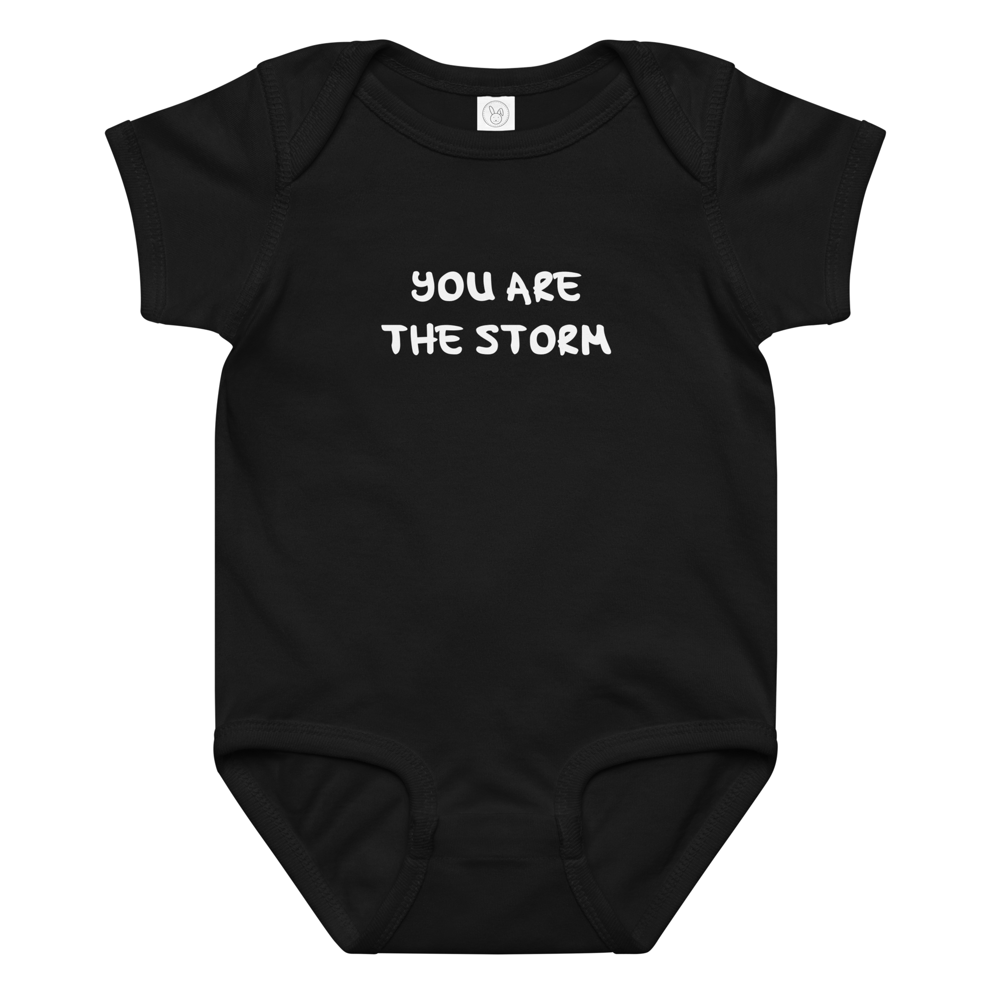 "You are the storm" printed on a black baby jersey bodysuit laying on a flat surface amongst other clothes