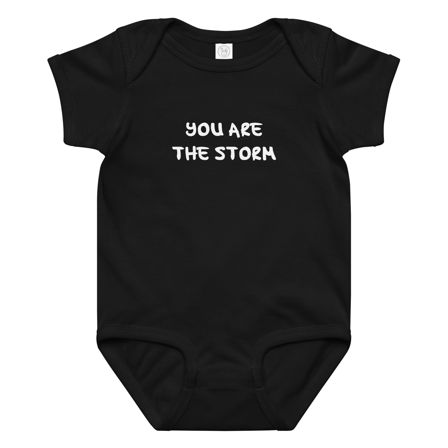 "You are the storm" printed on a black baby jersey bodysuit laying on a flat surface amongst other clothes
