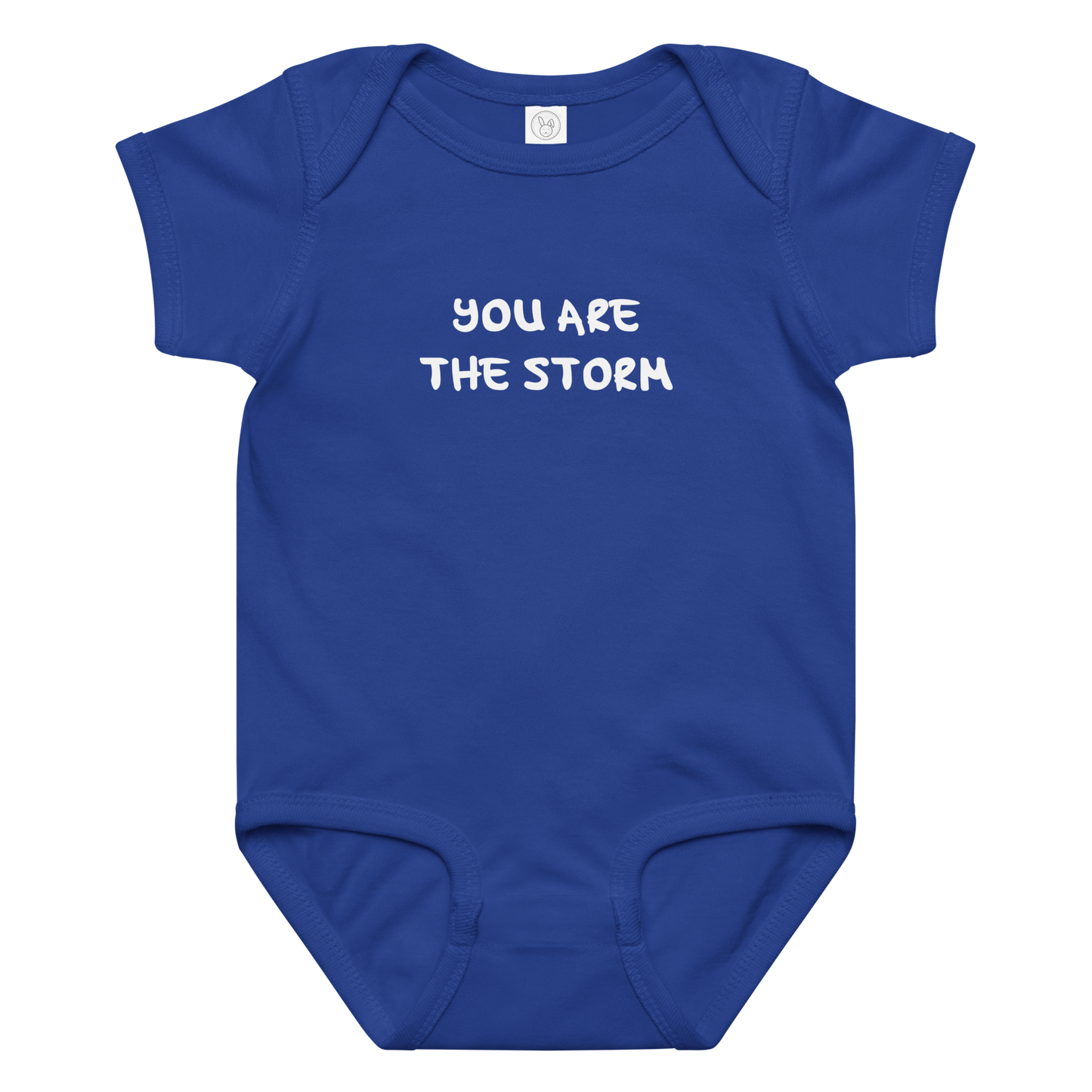 "You are the storm" printed on a royal baby jersey bodysuit laying on a flat surface amongst other clothes