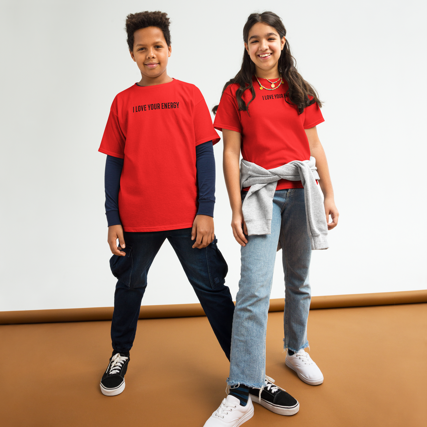 "I love your energy" printed on a red youth classic tee worn by a female and male