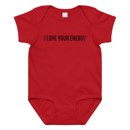 "I love your energy" printed on a red baby jersey bodysuit laying on a flat surface amongst other clothes