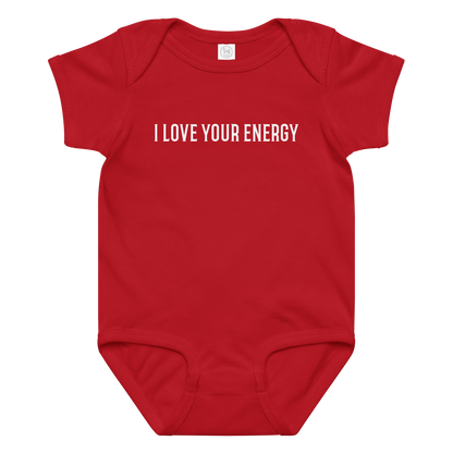 "I love your energy" printed on a red baby jersey bodysuit laying on a flat surface amongst other clothes